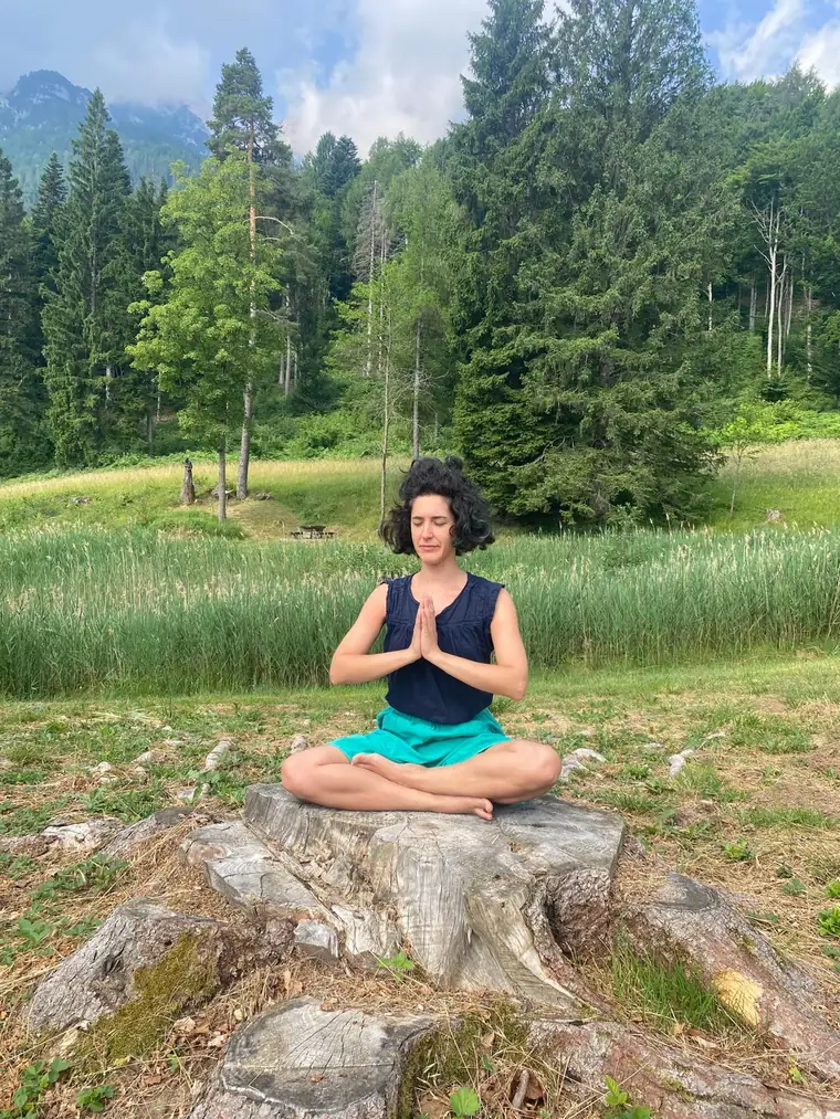Momento di meditazione seduta all'aperto, con le mani unite al centro del petto.